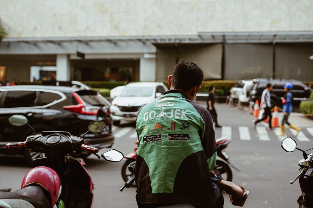 A Go-Jek rider waiting for his passenger. Go-Jek is a bike taxi app popular in Indonesia. 